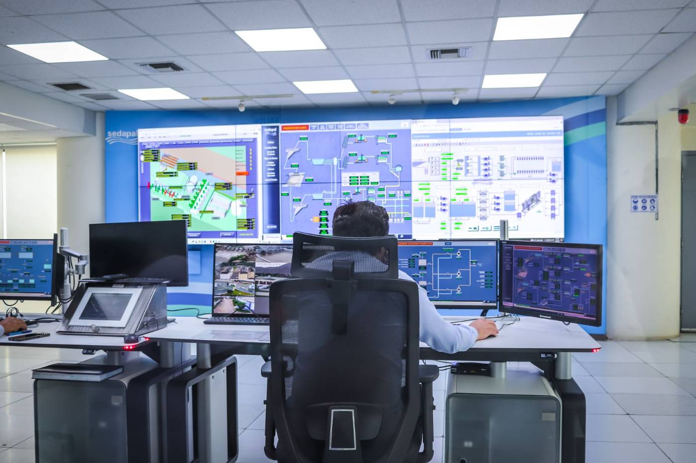 Operador em sala de controle diante de videowall